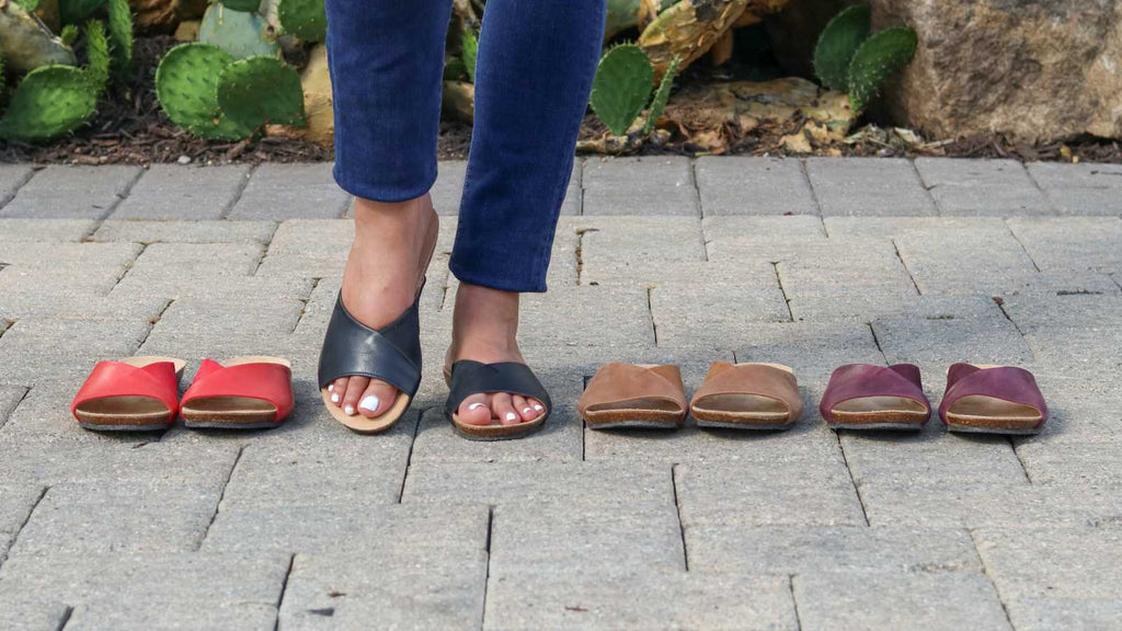 A woman showing off the various comfortable shoes for spring and summer. 