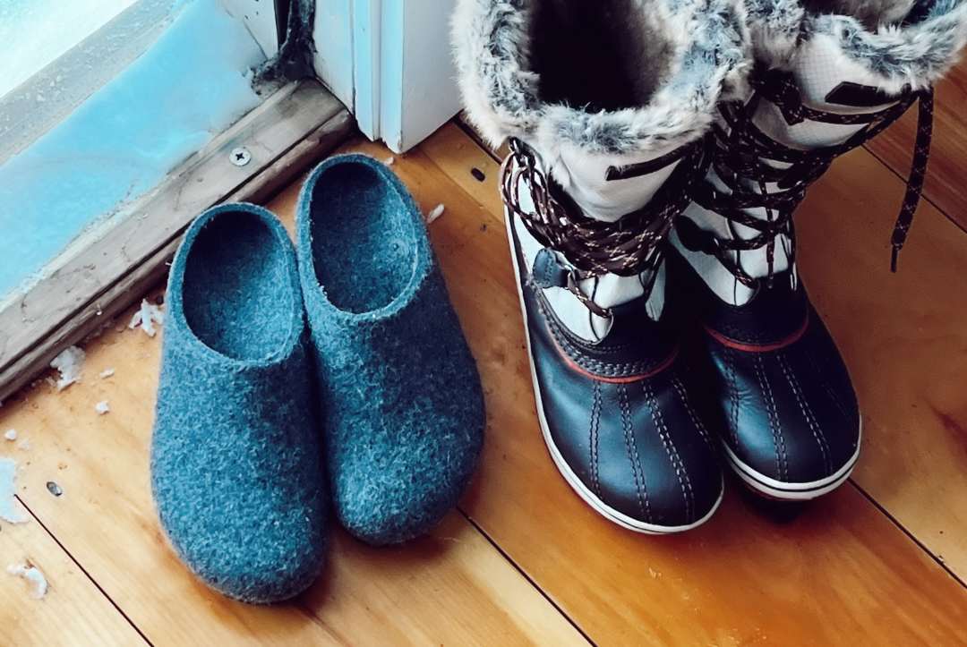 Cozy wool Stegmann clogs beside ski boots on a ski trip.