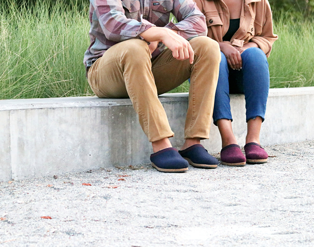 Two people sitting on a ledge with the popular Stegmann wool clogs.
