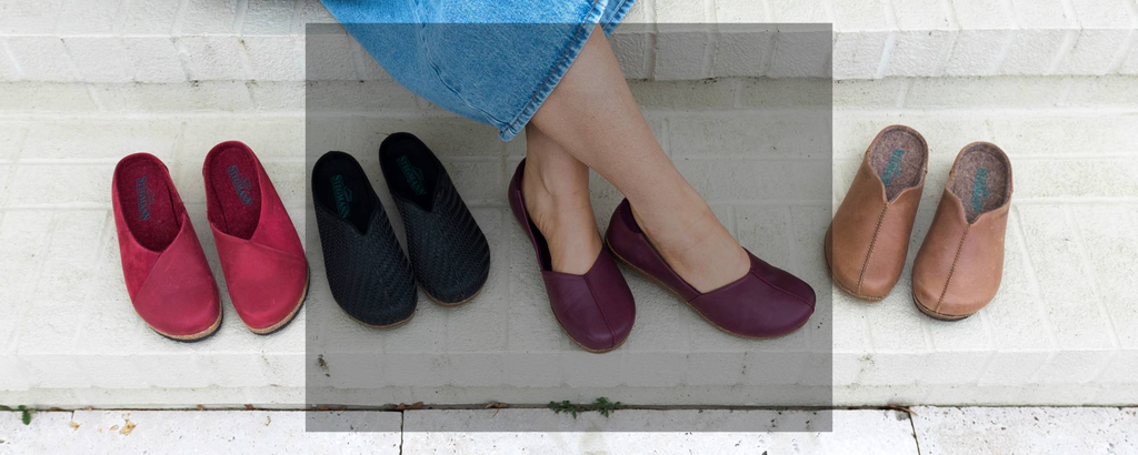 Two pairs of tan leather Stegmann slip-on shoes are placed side by side on a stone paver surface.