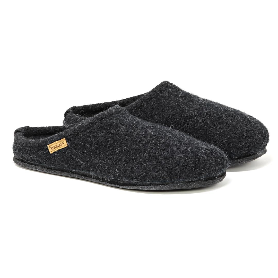 The Women's Alpine Comfort Wool Slipper is a pair of dark gray felt slippers made from merino wool with a small beige label on the side, set against a white background.