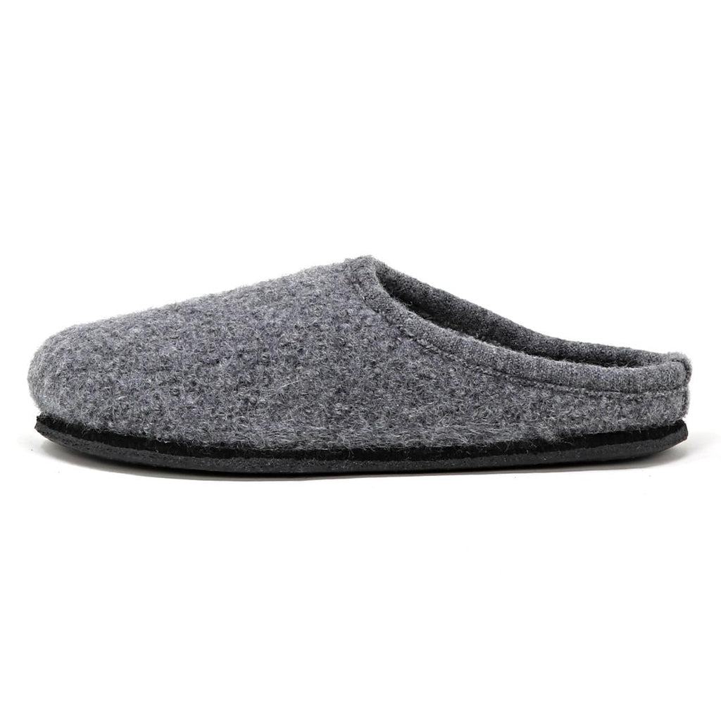 The Men's Alpine Comfort Wool Slipper features a soft gray merino wool upper, an anatomically shaped cork insole, and a black sole, shown from the side.