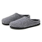 The Men's Alpine Comfort Wool Slipper features gray Merino wool uppers, black rubber soles, and anatomically shaped cork insoles for optimal comfort.