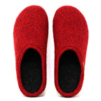 A pair of Women's Alpine Comfort Wool Slippers, featuring red felt wool exteriors, black interiors, and cork insoles, are displayed from above against a plain white background.