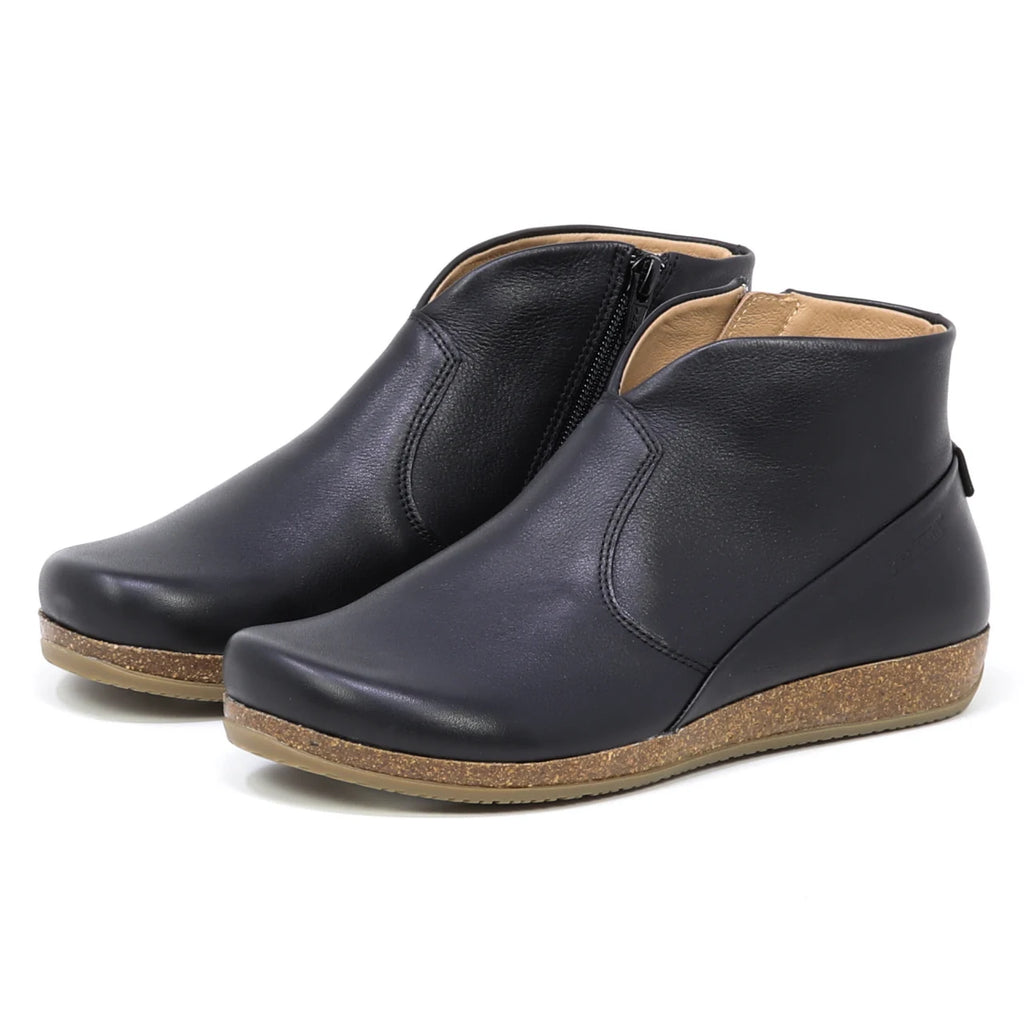 Women's Leather Amalia Boot in black features side zippers, tan cork soles, and a low wedge heel, shown on a plain white background.