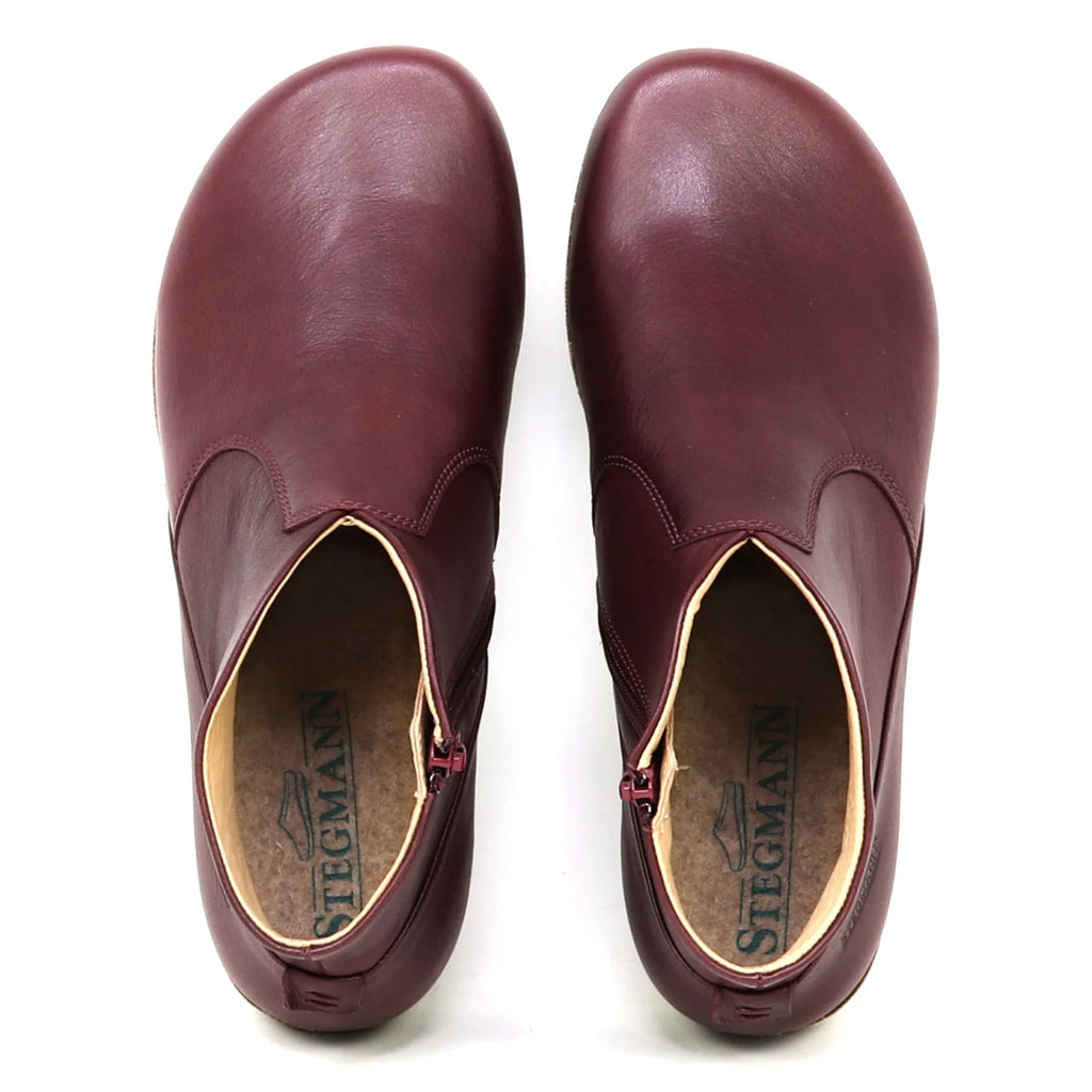 A pair of Women's Leather Amalia Boots in burgundy, viewed from above, with "Stegmann" branding visible on the insoles.