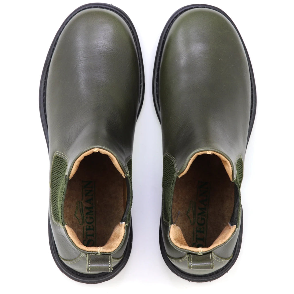 A pair of olive green Women’s Brenner Chelsea Boots with black soles, viewed from above. Crafted from premium Portuguese leather, the insoles are branded with the name “STEGMANN.”.