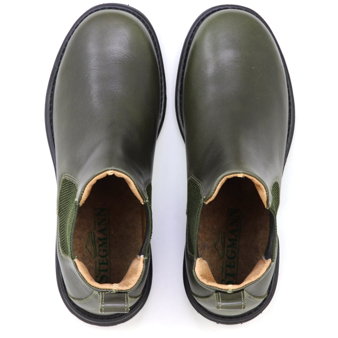 A pair of olive green Women’s Brenner Chelsea Boots with black soles, viewed from above. Crafted from premium Portuguese leather, the insoles are branded with the name “STEGMANN.”.