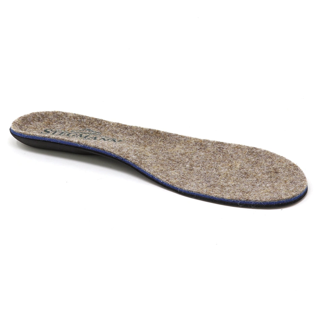 The Women’s Wool Contour Plus+ Replacement Insoles w/Arch are shown against a white background, featuring a brown felt material with a slightly curved shape and blue edging, designed to provide gentle arch support for enhanced comfort.