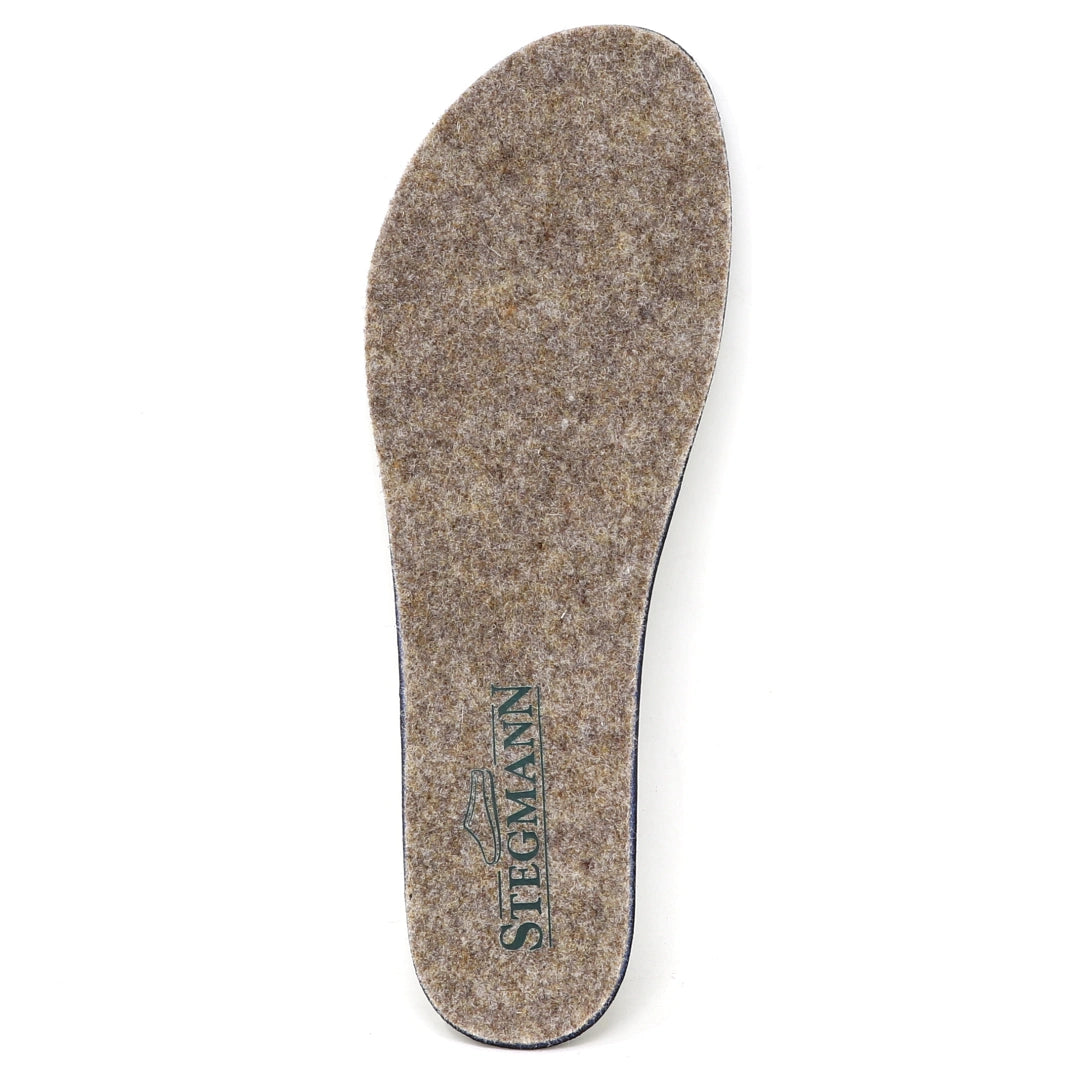 A single Women’s Wool Contour Plus+ Replacement Insole w/Arch in gray felt, featuring the word “Stegmann” and a green shoe logo printed near the heel, designed to offer enhanced arch support for lasting comfort.
