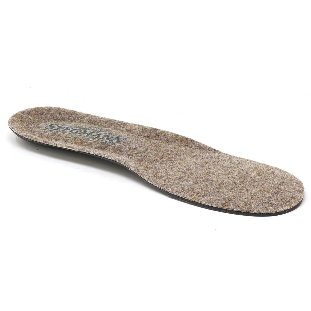 A single Women’s Wool Cushion Replacement Insole - No Arch in brown, featuring a slightly raised heel and shown from an angle against a white background, designed for a perfect fit inside Stegmann shoes.