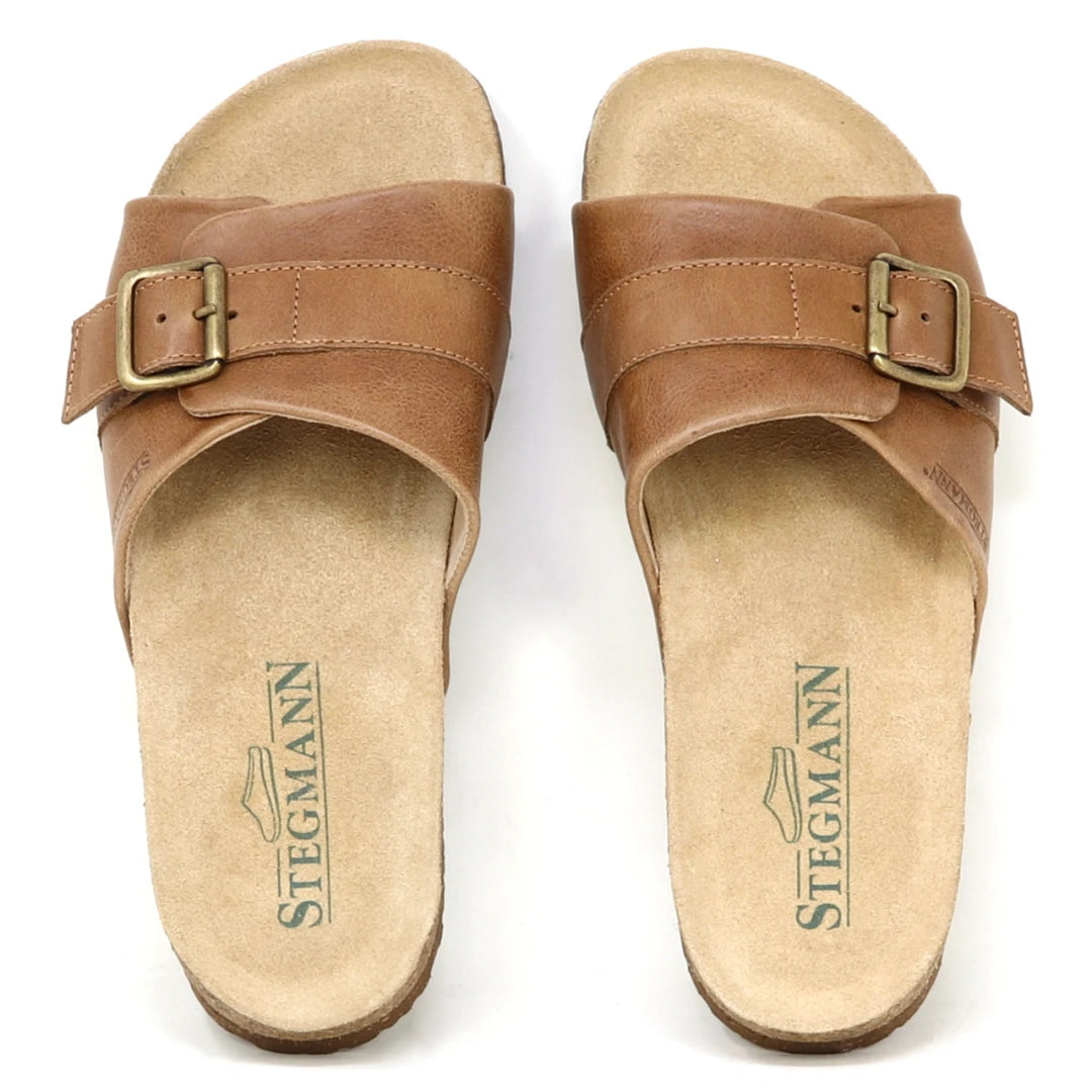 The Women's Ella Slide Sandal features tan leather, adjustable buckle straps, a contoured cork footbed, and "Stegmann" branding on the footbeds.