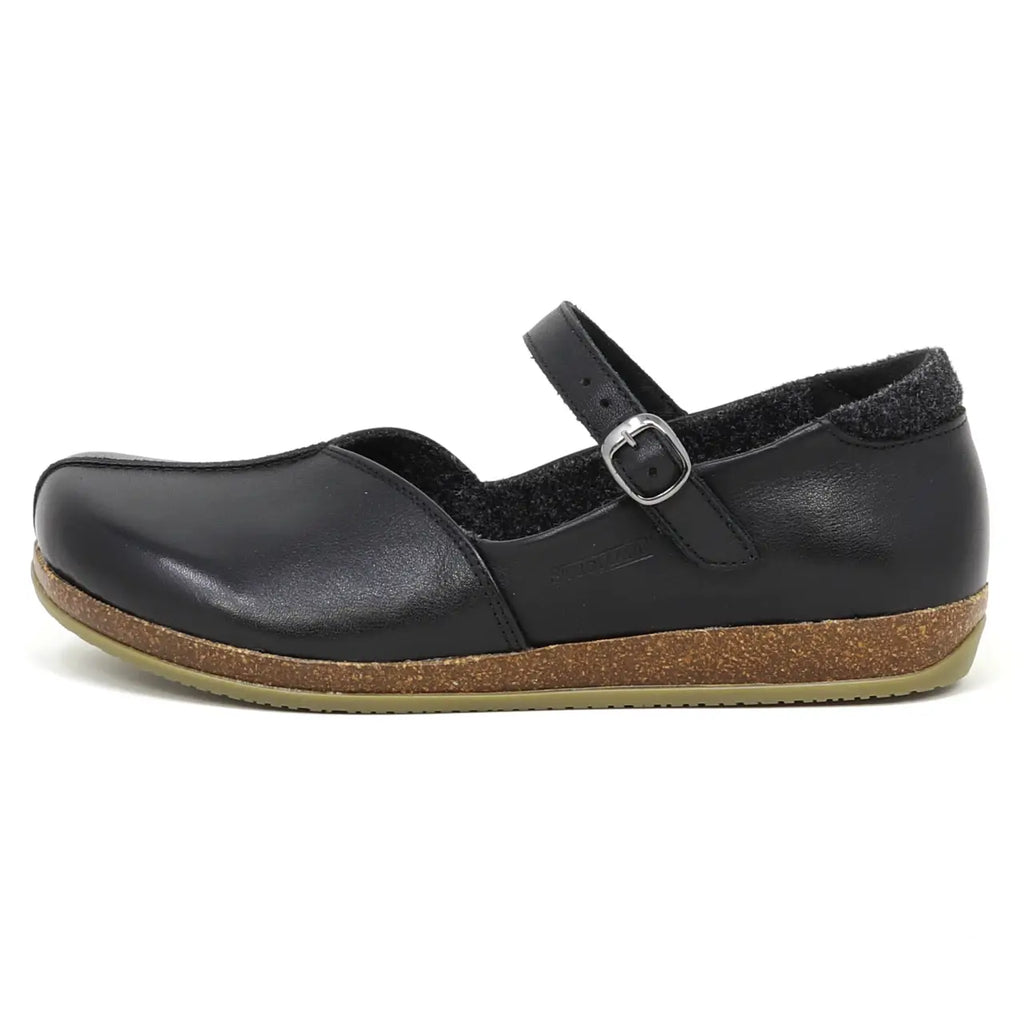 The Women's Eva Leather Mary-Jane is a black flat shoe made with vegetable-tanned leather, featuring a cork sole and an adjustable buckle strap.