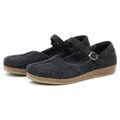 A pair of Women's Eva Wool Mary-Jane felt shoes in dark grey with a wide toe box, cork soles, and adjustable straps is displayed on a white background.