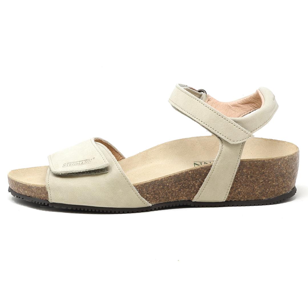 The Women's Freya Leather Wedge Sandal, shown in beige from the side, has a cork sole, adjustable ankle strap, and recycled rubber traction outsole.