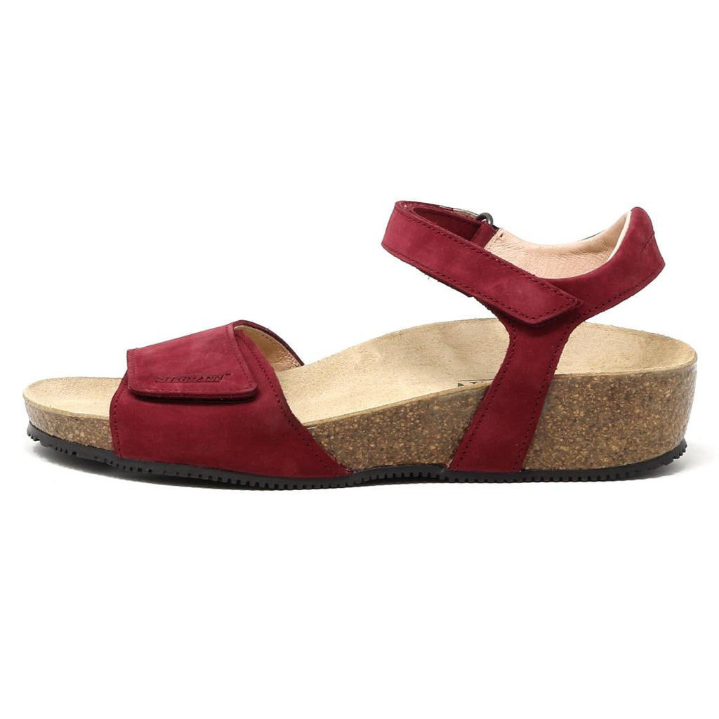 Introducing the Women's Freya Leather Wedge Sandal: a red sandal with a cork sole, featuring an ankle strap and front Velcro closure, now enhanced with arch support for extra comfort.