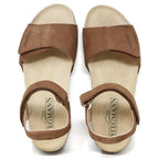 Women's Freya Leather Wedge Sandal: Brown leather sandals with adjustable straps and a flat beige sole, featuring the Stegmann logo on the insole. They offer excellent arch support and include a recycled rubber traction outsole for added stability.