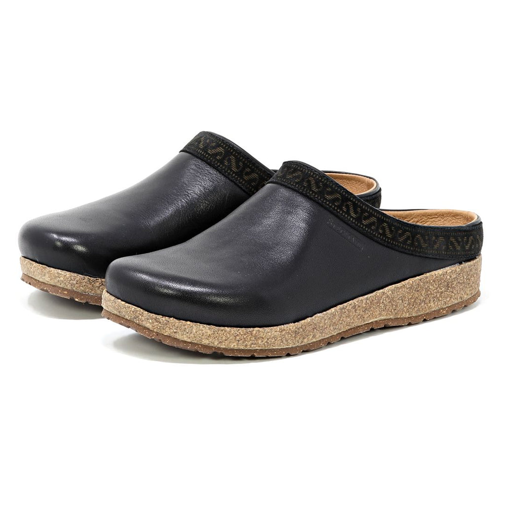Women's Graz Leather Clog features black vegetable-tanned leather with cork soles and patterned trim, offering a bunion-friendly design, shown at an angle view from the front.