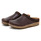 The Women's Graz Leather Clogs feature vegetable-tanned leather in rich brown, cork soles, and dark patterned trim. Their design ensures style and comfort for bunions, presented elegantly against a crisp white backdrop.