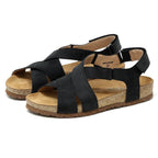 The Women's Hannah Leather Sandal features black open-toe design with cork soles, adjustable ankle straps, a cushioned suede footbed, and arch support for style and comfort. Perfect for any occasion, they're elegantly displayed on a white background.
