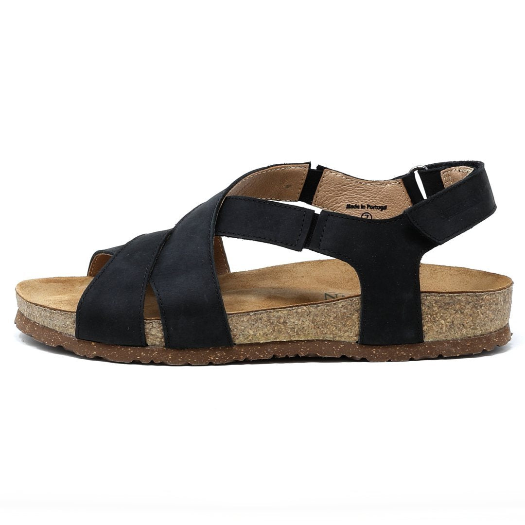 The Women's Hannah Leather Sandal - Medium is a black strappy sandal with a cork sole, displayed in a side view on a white background. It includes a cushioned suede footbed and arch support, combining style and comfort.