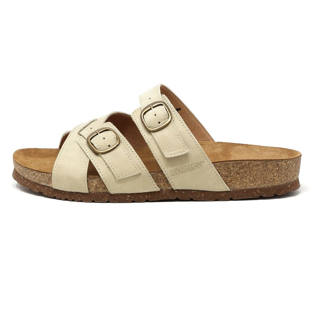 The Women's Heidi Leather Sandal is a beige slip-on with two adjustable straps, an ultra-cushy footbed, and a cork sole, shown from the side.