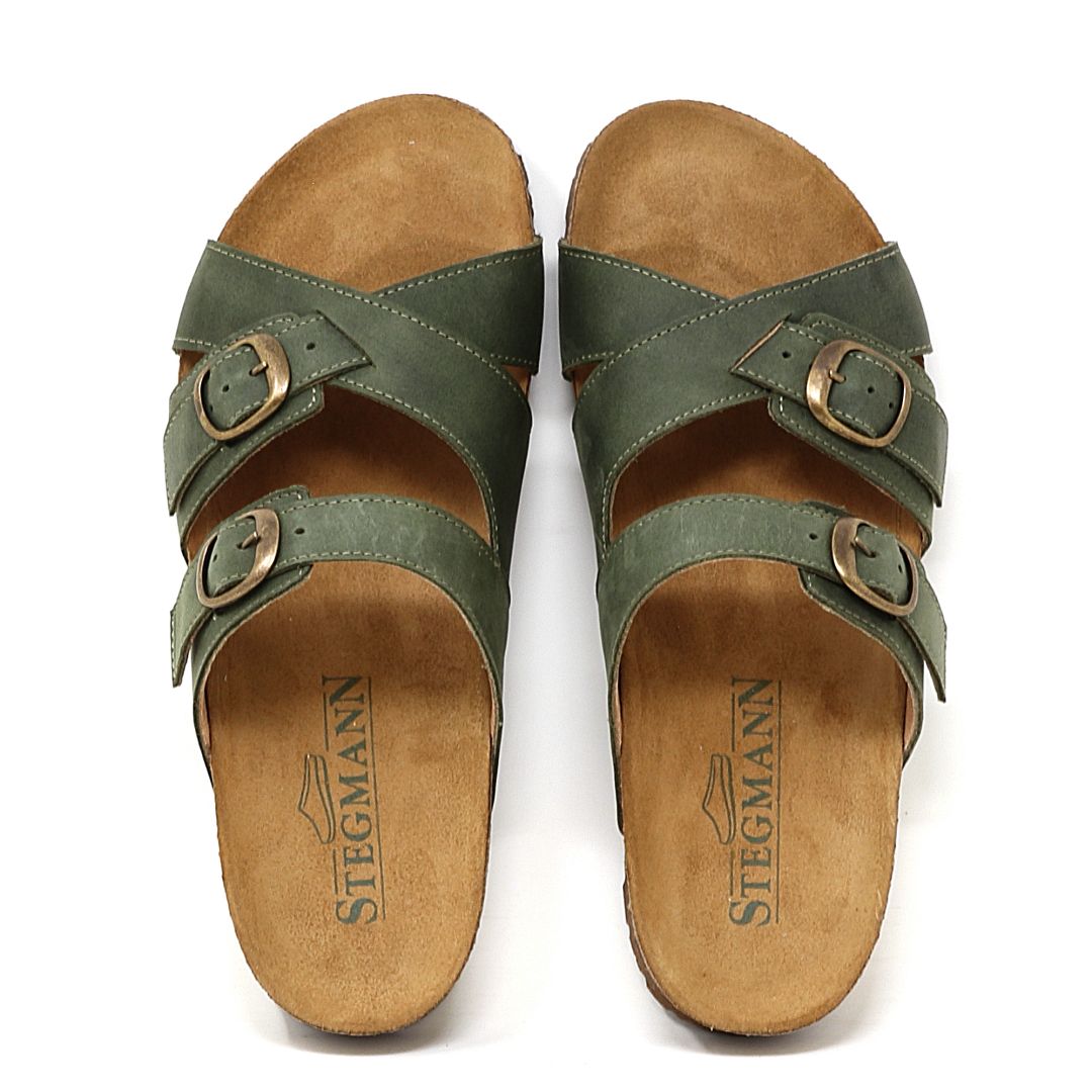 A pair of "Women's Heidi Leather Sandal - Medium" in green with adjustable straps, brown buckles on a white background, featuring an ultra-cushy footbed and the "Stegmann" logo on the insoles.