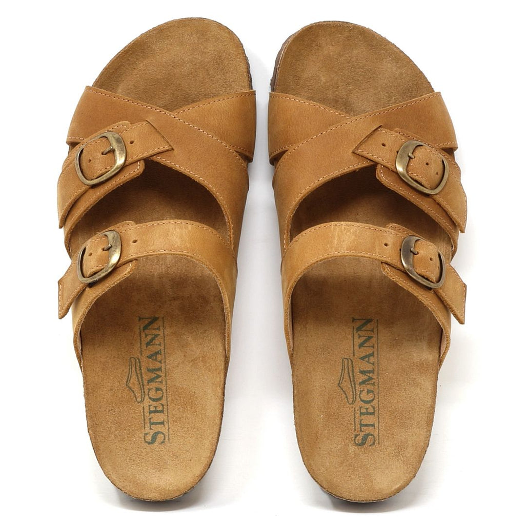 Women's Heidi Leather Sandals in tan leather feature adjustable buckle straps and "Stegmann" printed insoles. They include a sustainable cork midsole for enhanced comfort, viewed from above.