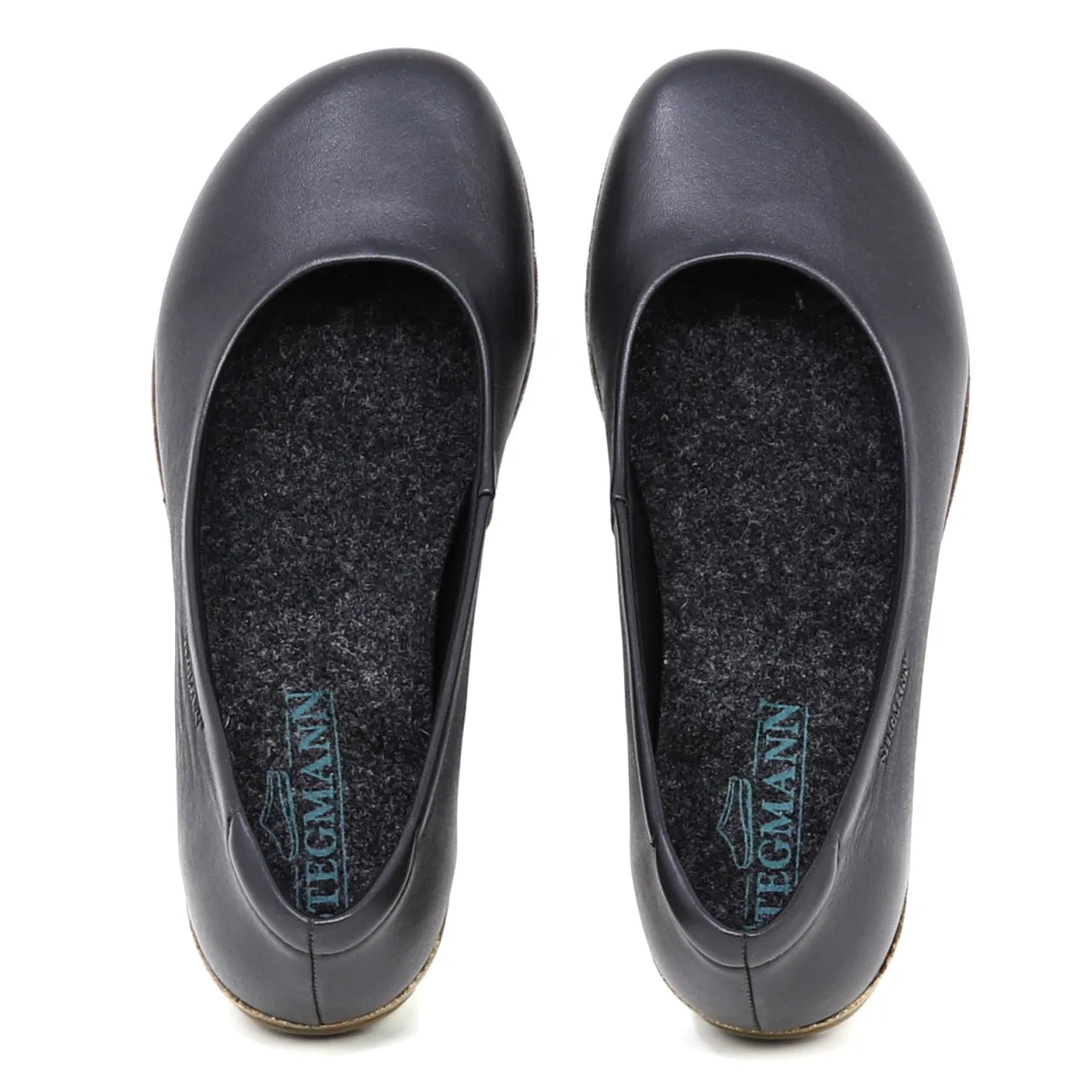 The Women's Helene Ballet Flat is a black leather shoe with rounded toes, seen from above. Each features a grey insole with blue Tegmann branding and subtle arch support for comfort.