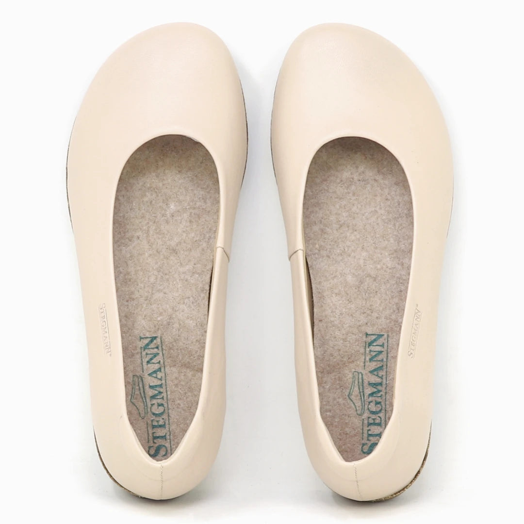 The Women's Helene Stretch Leather Ballet Flat is a beige, round-toe slip-on with felt insoles, designed for bunion-friendly comfort and "Stegmann" branding inside.