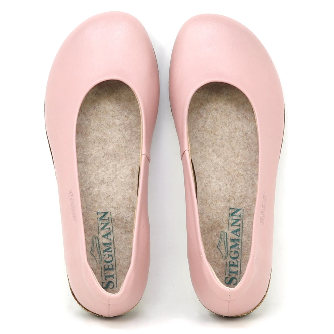 A pair of Women's Helene Stretch Leather Ballet Flats in light pink with rounded toes, viewed from above. These bunion-friendly shoes feature beige insoles with the Stegmann logo, offering stylish support and potential plantar fasciitis relief.