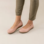 Woman wearing light pink Women's Helene Stretch Leather Ballet Flats with a slight wedge heel and olive green pants on a light floor—ideal for bunion comfort and plantar fasciitis pain relief.