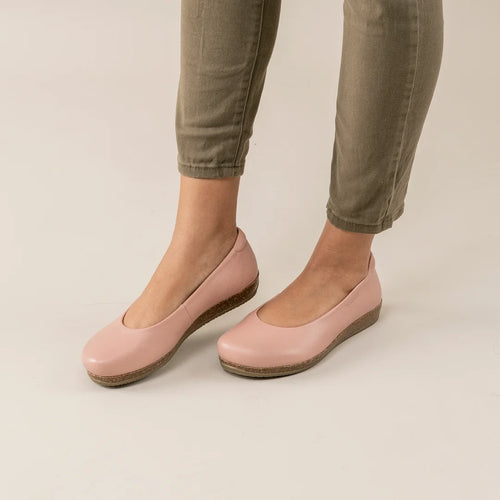 Woman wearing light pink Women's Helene Stretch Leather Ballet Flats with a slight wedge heel and olive green pants on a light floor—ideal for bunion comfort and plantar fasciitis pain relief.