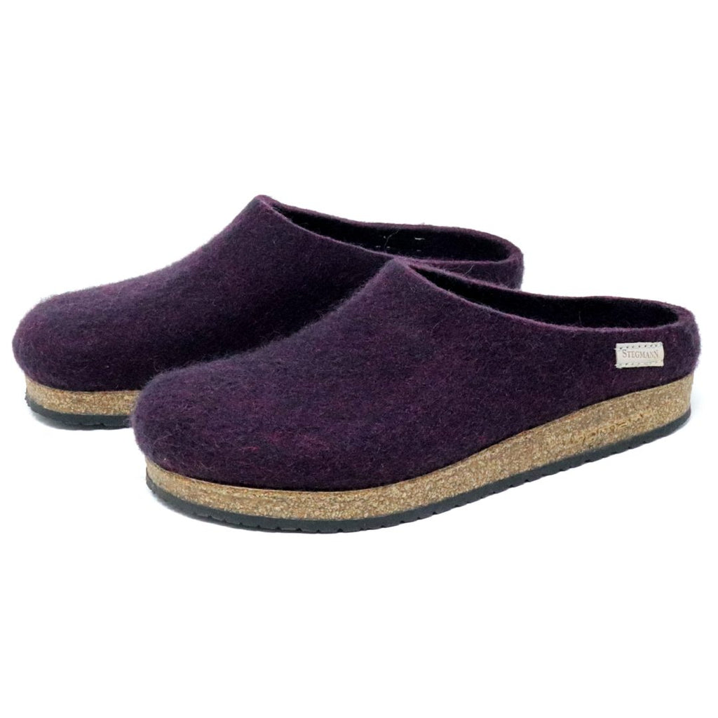 The Women's Essenz Wool Clog, crafted from luxurious dark purple Merino wool and featuring cork soles, is displayed from the side.