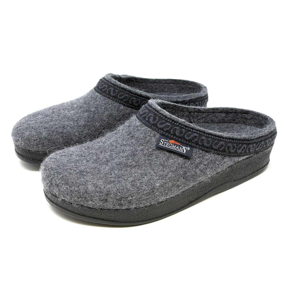 The Women's WoolFlex Wool Clog - Medium features a gray Merino wool upper with an anatomically contoured sole, black soles, and a patterned trim. A "Stegmann" label decorates the side for style and cushion comfort.