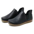 The Women's Lieben Leather Chelsea Boot is a black slip-on with closed toes, elastic side panels, brown textured soles, and a cozy wool felt lining, shown on a white background.