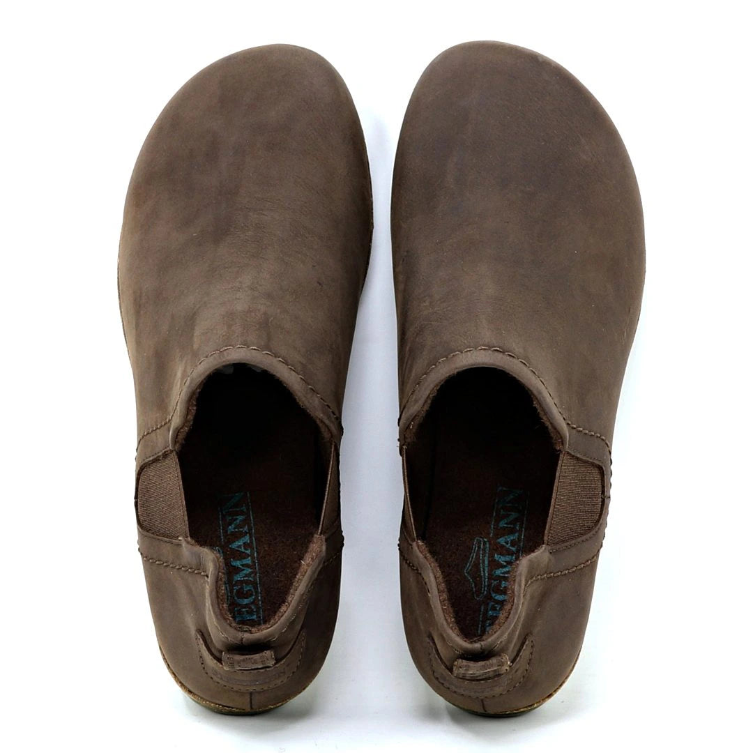 The Women's Lieben Leather Chelsea Boot is a brown, slip-on leather shoe with elastic side panels, branded insoles, and made from vegetable tanned leather, inspired by the classic Chelsea boot style.