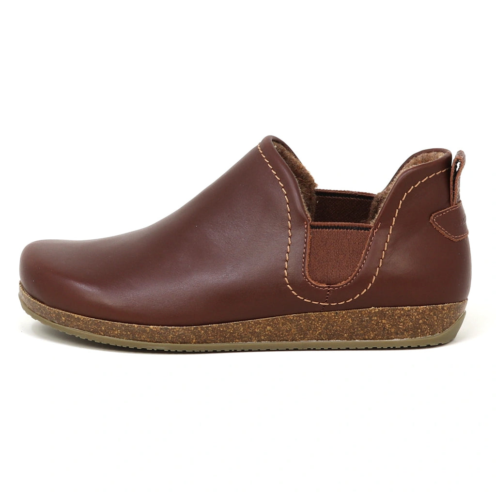 The Women's Lieben Leather Chelsea Boot features vegetable-tanned brown leather, tan stitching, elastic side panels, a cork-textured sole, and soft wool felt lining, shown in left side profile.