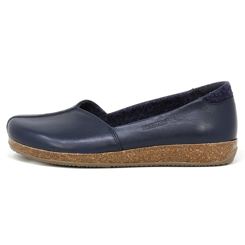 A side view of the Women’s Liesl Leather Skimmer in navy blue, featuring a slip-on design, cork sole, and wide toe box, set against a white background.