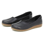 The Women's Liesl Leather Skimmer features black slip-on style, a wide toe box, cork soles, and a simple design, shown on a plain white background.
