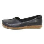 The Women's Liesl Leather Skimmer is a black slip-on shoe featuring a leather upper, arch support, cork-textured midsole, and flat rubber outsole, shown from the left side profile.
