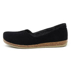 The Women's Liesl Wool Skimmer is a black slip-on with a wide toe box, cork-like sole, and slightly textured wool upper for women, shown in side profile.