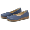 The Women's Liesl Stretch Leather Skimmer is a pair of blue slip-on shoes with rounded toes, wide toe box, cork-textured soles, and buttery-soft leather, displayed against a white background.
