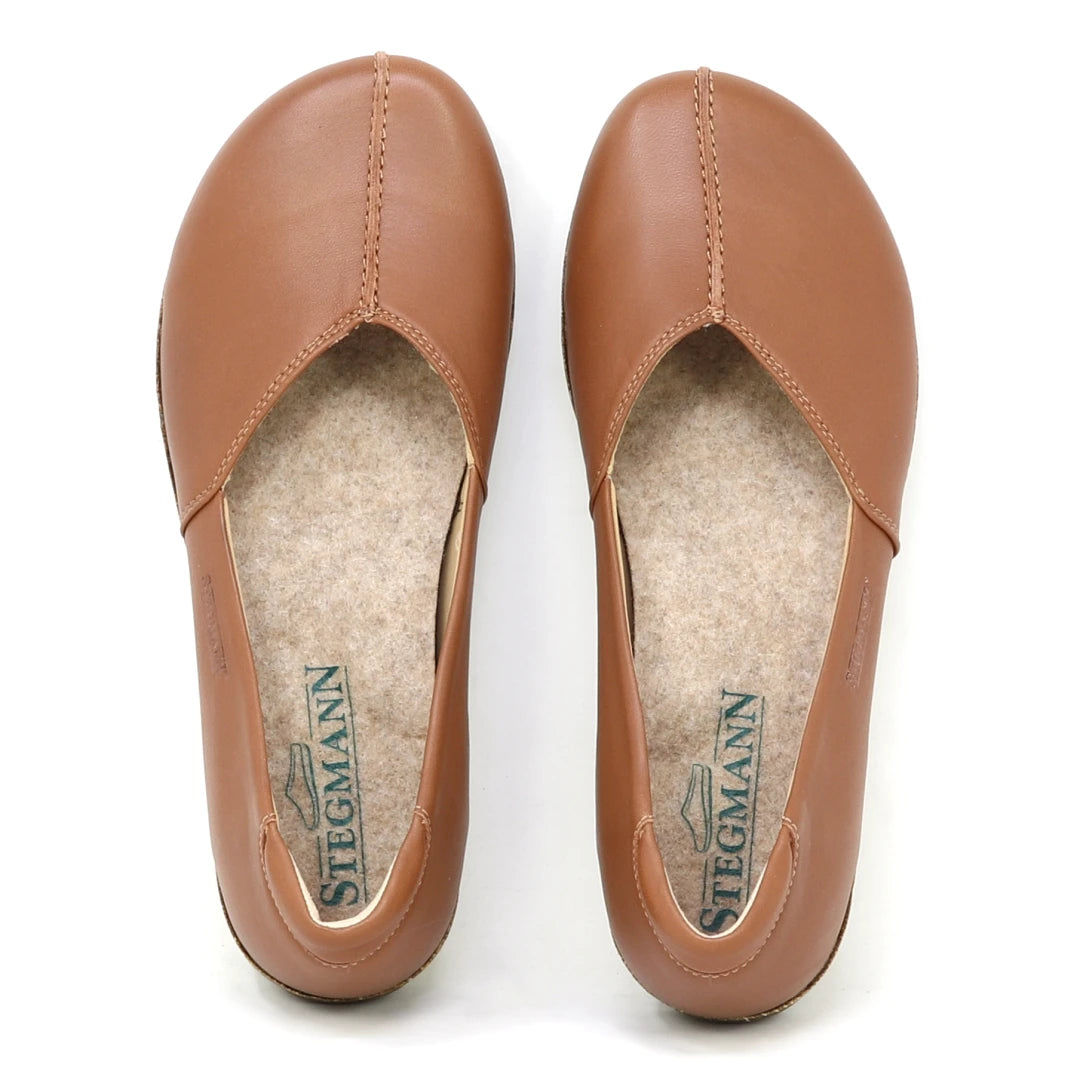 The Women's Liesl Stretch Leather Skimmer features buttery-soft light brown leather, visible stitching, felt insoles with STEGMANN branding, and a wide toe box for comfort.