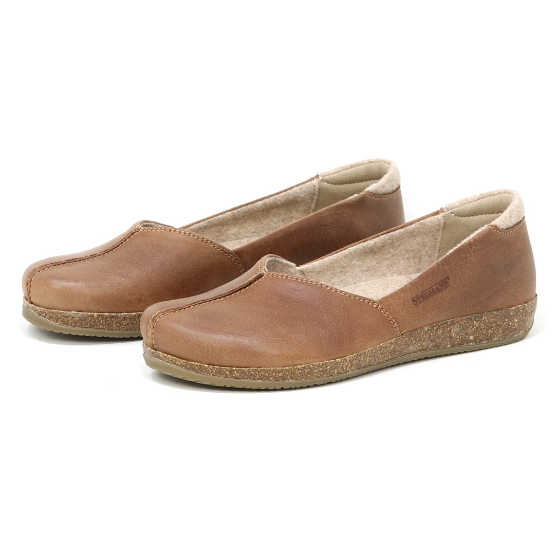 A pair of Women's Liesl Leather Skimmer shoes in brown leather, featuring a wide toe box, flat cork soles, and a light-colored inner lining, displayed on a white background.