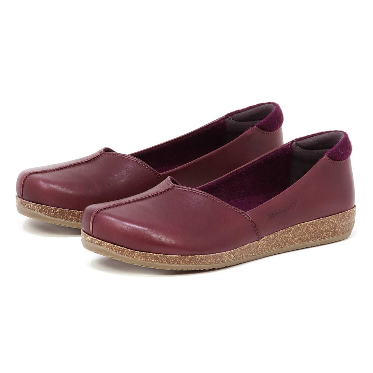 Women’s Liesl Leather Skimmer: Maroon leather slip-on flats for women featuring a wide toe box, cork soles, low heels, and purple inner lining, shown on a white background.