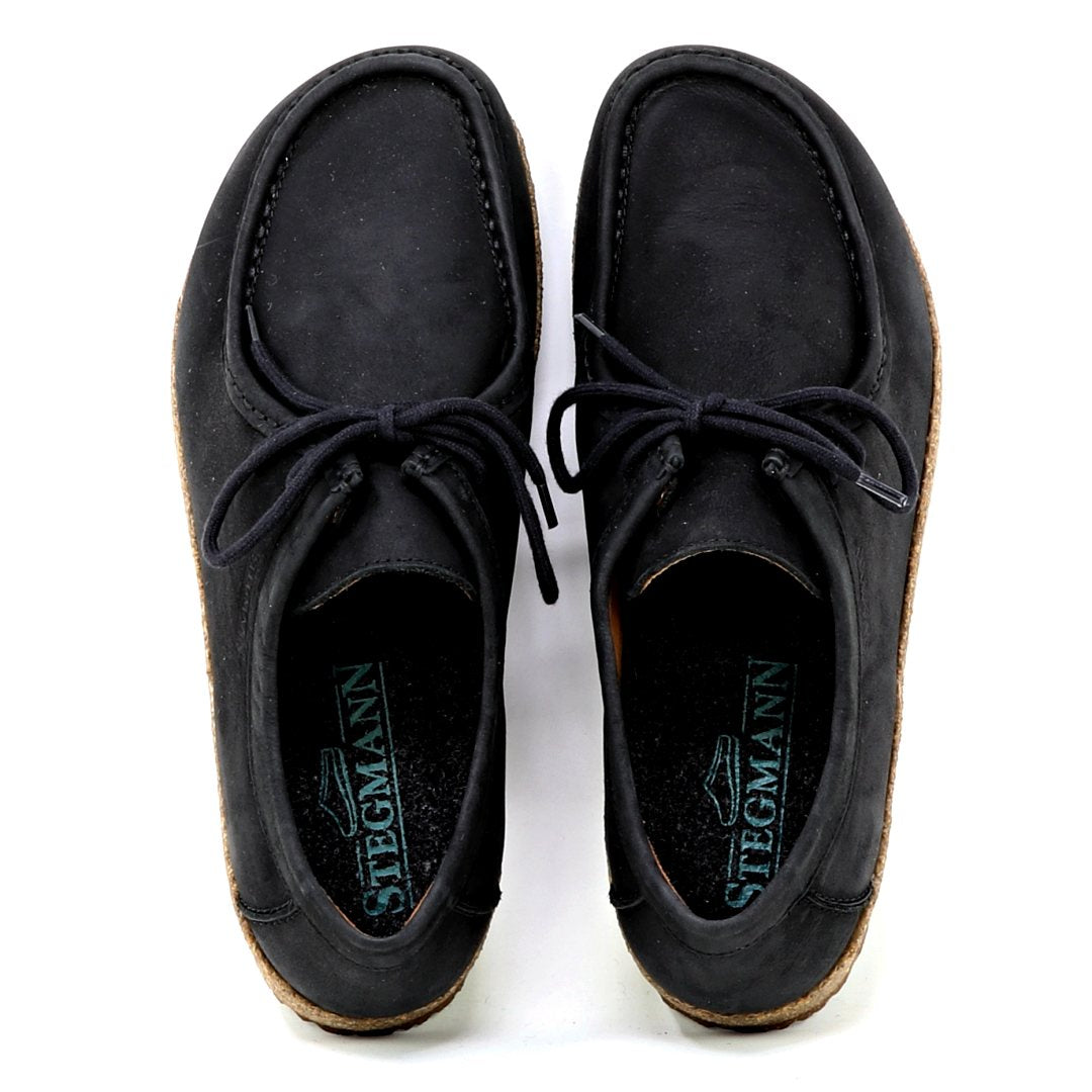 The Women's Mainz Leather Moc Shoe in black features an oiled leather upper with visible stitching and branded insole. Designed for style and everyday comfort, it includes an UltraComfort footbed for enhanced support.