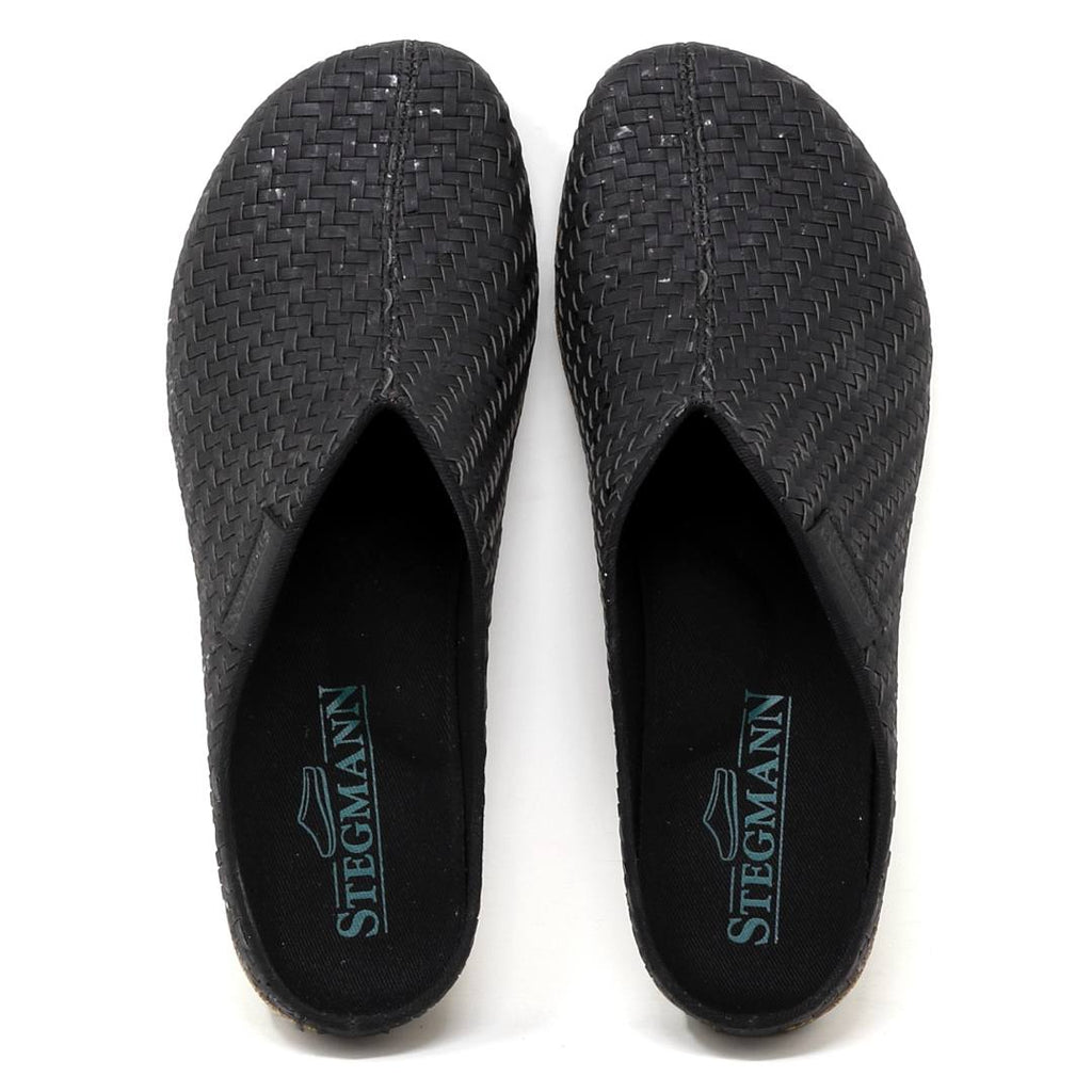 The Women's Maria Woven Cork Mule features black slip-on shoes branded "STEGMANN" on the insole, crafted with sustainable cork for comfort and arch support.