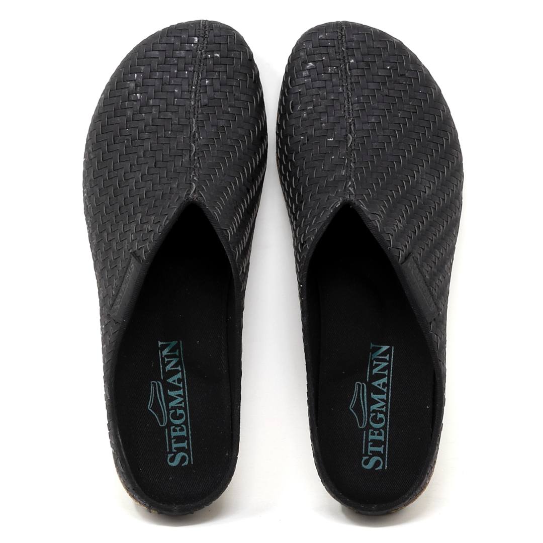 The Women's Maria Woven Cork Mule features black slip-on shoes branded "STEGMANN" on the insole, crafted with sustainable cork for comfort and arch support.