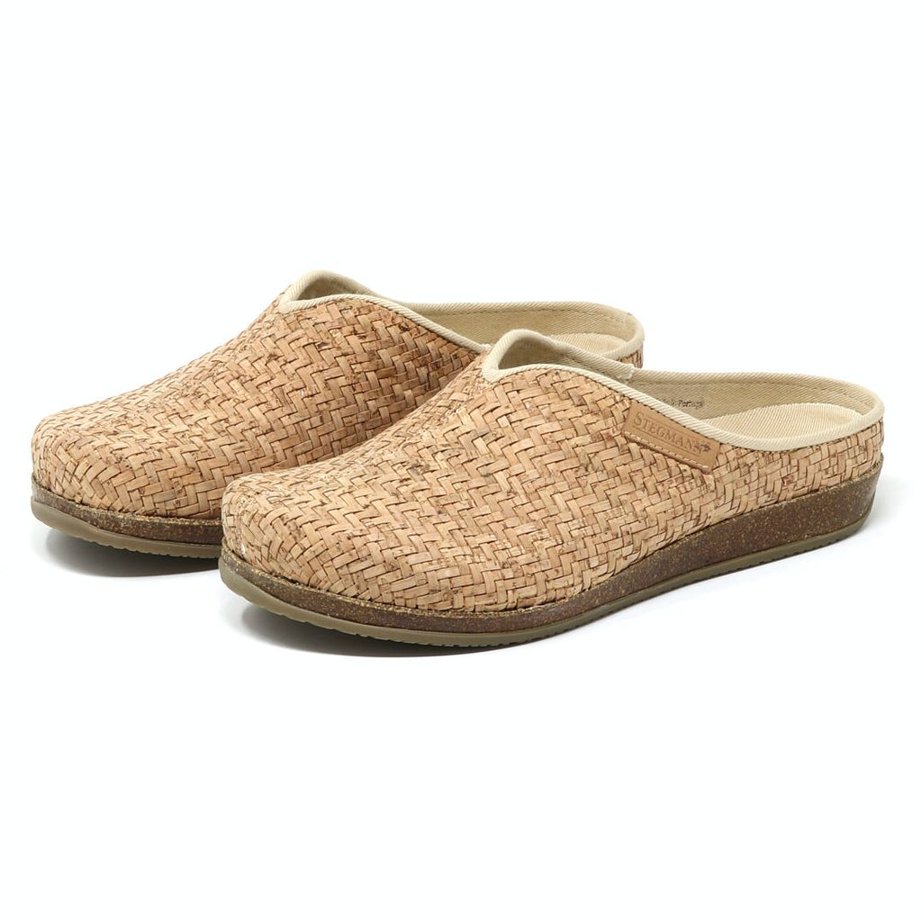 The Women's Maria Woven Cork Mule features a pair of slip-on clogs with brown soles, showcasing sustainable cork footbeds for enhanced arch support, viewed from the side.